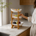 White three-tier fruit basket stand in a warm kitchen setting